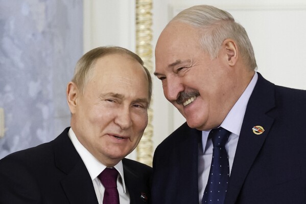 Russian President Vladimir Putin, left, and Belarus President Alexander Lukashenko shake hands during a meeting of the Union State Supreme Council in St. Petersburg, Russia, Monday, Jan. 29, 2024. (Dmitry Astakhov, Sputnik, Government Pool Photo via AP)