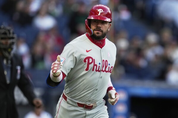 Philadelphia Phillies' Kyle Schwarber gestures to the dugout as he runs toward first base with a home run in the second inning of a baseball game against the Cleveland Guardians in Cleveland, Sunday, May 11, 2025. (AP Photo/Sue Ogrocki)