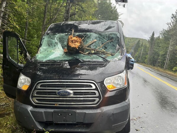 This image offered by Maine Command Police reveals the vehicle of an Ohio driver who suffered minor accidents Saturday, Sept. 16 2023 after tree downed by the remnants of tropical storm Lee went by his windshield on Route 11 in Moro Plantation, Maine, in accordance to Maine Command Police. John Yoder, 23, of Apple Creek, Ohio attempted to stop however couldn’t reduction a long way from the tree. Yoder suffered minor cuts however the different five passengers within the van weren't injured. Police blamed high winds for the downed tree. (Maine Command Police via AP)