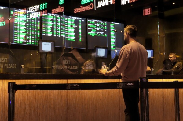 FILE - A customer makes a sports bet at the Borgata casino in Atlantic City N.J. on March 17, 2022 just before the March Madness NCAA college basketball tournament began. As March Madness gets underway, more people than ever now can legally bet on sports. A total of 38 states and the District of Columbia now allow some form of sports betting. (AP Photo/Wayne Parry, File)