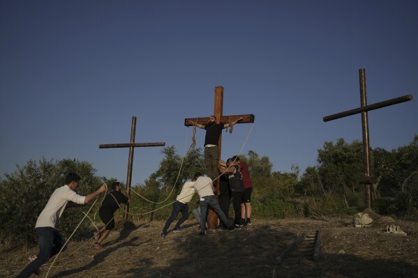 Members of the Maronite Church of St. George rehearse a crucifixion scene as part of preparations for the traditional Good Friday procession in Quraye, near the southern port city of Sidon, Lebanon, Thursday, April 17, 2025. (AP Photo/Hassan Ammar)