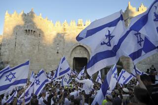 FILE - Jewish ultra-nationalists wave Israeli flags during the "Flags March," next to Damascus gate, outside Jerusalem's Old City, June 15, 2021. Israeli authorities on Wednesday, May 18, 2022, said they have given the go-ahead for flag-waving Jewish nationalists to march through the heart of the main Palestinian thoroughfare in Jerusalem's Old City on May 29, in a decision that threatens to re-ignite violence in the holy city. (AP Photo/Mahmoud Illean, File)