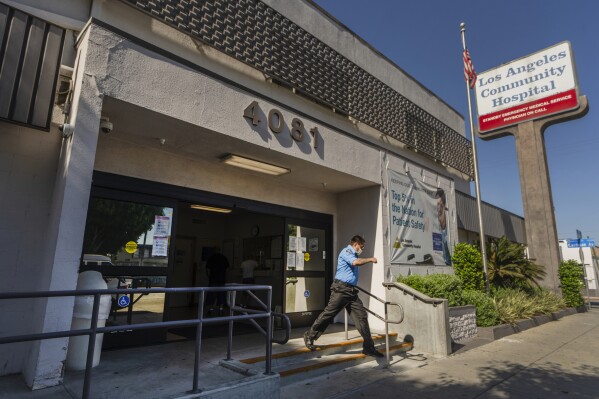 A man leaves the Los Angeles Community Hospital in Los Angeles on Friday, Aug. 4, 2023. Hospitals, including this one, and clinics in several states on Friday began the time-consuming process of recovering from a cyberattack that disrupted their computer systems, forcing some emergency rooms to shut down and ambulances to be diverted. (AP Photo/Damian Dovarganes)