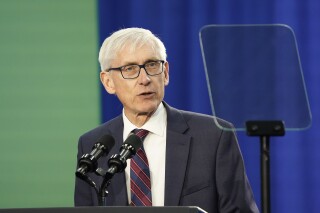 FILE - Wisconsin Gov. Tony Evers speaks prior to President Joe Biden's appearance at an event about canceling student debt, Monday, April 8, 2024, at the Madison Area Technical College Truax campus in Madison, Wis. Attorneys with Wisconsin's largest business lobbying group asked the state Supreme Court on Monday, April 15, to strike down Evers' use of a partial veto to lock in a school funding increase for the next 400 years. (AP Photo/Kayla Wolf, File)