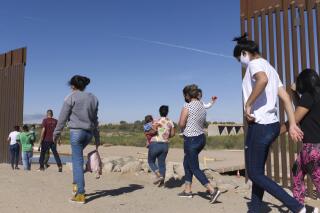 FILE - A group of Brazilian migrants make their way around a gap in the U.S.-Mexico border in Yuma, Ariz., seeking asylum in the U.S. after crossing over from Mexico, June 8, 2021. The U.S. Department of Homeland Security says migrants entering the country illegally will be screened by asylum officers while in custody under a limited experiment that provides them access to legal counsel. (AP Photo/Eugene Garcia, File)