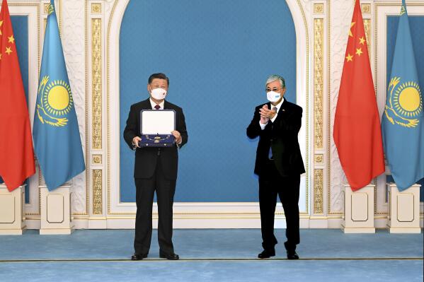 In this photo released by Xinhua News Agency, Chinese President Xi Jinping, left, receives the Order of the Golden Eagle, or "Altyn Qyran" Order, awarded by Kazakhstan's President Kassym-Jomart Tokayev at the Ak Orda Presidential Palace in Nur-Sultan, Kazakhstan, Wednesday, Sept. 14, 2022. (Rao Aimin/Xinhua via AP)