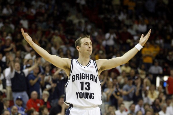Brigham Young's Austin Ainge raises his hands to the crowd during the final seconds of a Mountain West conference men's basketball tournament game against Wyoming in Las Vegas, March 9, 2007. (AP Photo/Isaac Brekken, File)