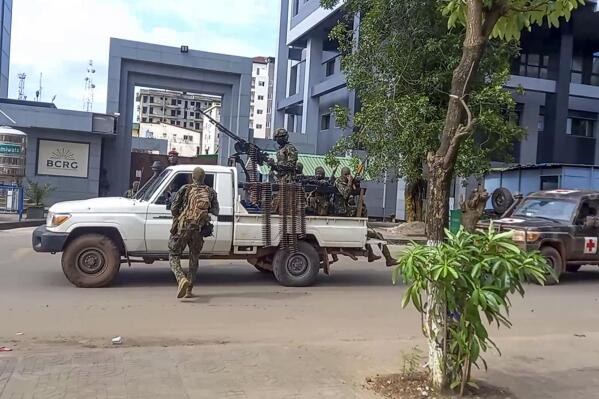 In this image made from video, unidentified soldiers patrol in a vehicle near the office of the president in the capital Conakry, Guinea Sunday, Sept. 5, 2021. Guinea's new military leaders sought to tighten their grip on power after overthrowing President Alpha Conde, warning local officials that refusing to appear at a meeting convened Monday would be considered an act of rebellion against the junta. (AP Photo)