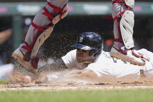 Detroit Tigers third base Andy Ib·Òez slides safely into home plate under Cleveland Guardians catcher Austin Hedges in the fourth inning during a baseball game, Sunday, May 25, 2025, in Detroit. (AP Photo/Paul Sancya)