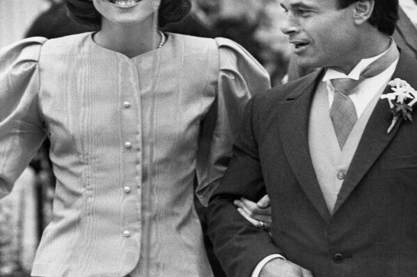 FILE - In this April 26, 1986 file photo, maid of Honor Caroline Kennedy and Best Man Franco Columbu, leave St. Francis Xavier Church after the wedding of Caroline's cousin Maria Shriver to Arnold Schwarzenegger in Hyannis, Mass.. Italian bodybuilder, boxer and actor Franco Columbu, one of Arnold Schwarzenegger's closest friends, has died aged 78. Columbu died in a hospital in his native Sardinia on Friday, Aug. 30, 2019 afternoon after being taken ill while he was swimming in the sea. (AP Photo/Mike Kullen, file)