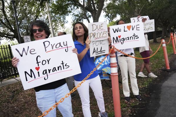 Advocates for migrant rights hold signs outside the South Florida office of U.S. Immigration and Customs Enforcement and Enforcement and Removal Operations, following a press conference with Gov. Ron DeSantis on immigration enforcement, Thursday, May 1, 2025, in Miramar, Fla. (AP Photo/Rebecca Blackwell)