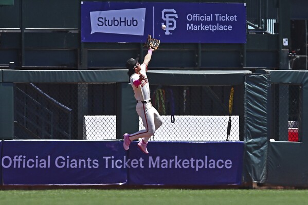 San Francisco Giants' Jung Hoo Lee fails to catch a fly ball hit by Cincinnati Reds' Jeimer Candelario in the first inning of a baseball game in San Francisco, Sunday, May 12, 2024. Lee would leave the game after injuring himself during the play. (Jose Carlos Fajardo/Bay Area News Group via AP)