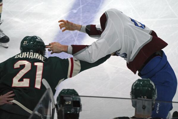Colorado Avalanche's Logan O'Connor, right, has trouble finding Minnesota Wild's Brandon Duhaime (21) during a fight in the first period of an NHL hockey game Friday, April 29, 2022, in St. Paul, Minn. Both received fighting penalties. (AP Photo/Jim Mone)