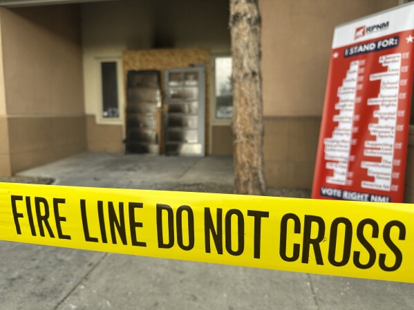 The charred entrance doors to the Republican Party of New Mexico headquarters sit propped up behind yellow tape in Albuquerque, New Mexico, on Monday, March 31, 2025. (AP Photo/Susan Montoya Bryan)