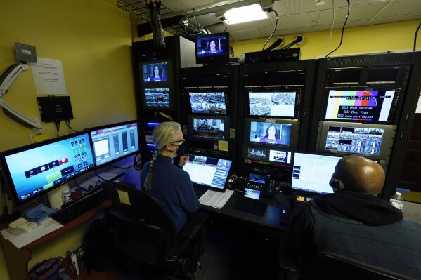 FILE - In this  Feb. 10, 2021, file photo, Virginia Public Media techs, Roberta Fallon, left, and Phillip Newsome, right, monitor the video feeds during a Virginia House of Delegates Zoom Legislative session at the Capitol in Richmond, Va. A year after COVID-19 triggered government shutdowns and crowd limitations, more public bodies than ever are livestreaming their meetings for anyone to watch from a computer, television or smartphone. But in some cases, it's become harder for people to actually talk with their elected officials. (AP Photo/Steve Helber, File)