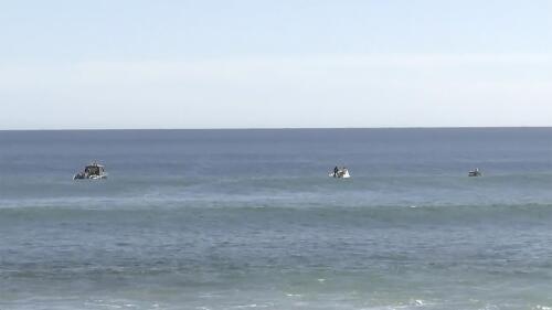 In this image from a video, searchers on boats conduct an operation in waters in Elliston, Australia Saturday, May 13, 2023. Police continued to search Monday for remains of a 46-year-old surfer who was attacked by a shark off the south Australian coast two days earlier. (Australian Broadcasting Corp. via AP)