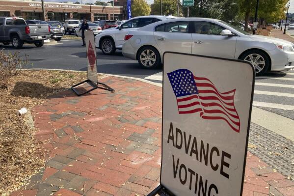 A sign showing the way for voters stands outside a Cobb County voting building during the first day of early voting, Monday, Oct. 17, 2022, in Marietta, Ga. (AP Photo/Mike Stewart)