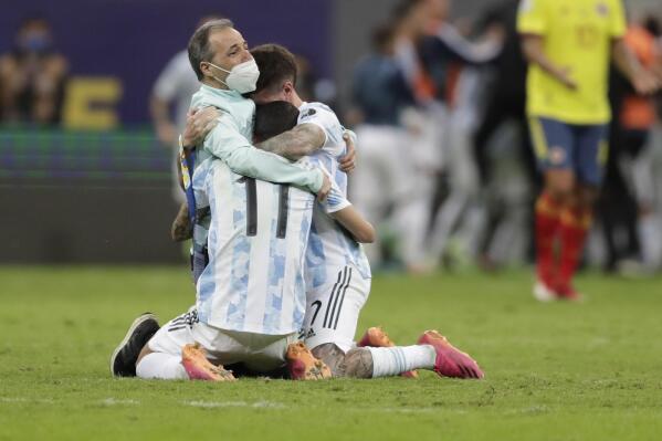 Argentina's players Angel Di Maria, center, and Rodrigo De Paul, right, embrace a member of the team after defeating Colombia in a penalty shootout during a Copa America semifinal soccer match at the National stadium in Brasilia, Brazil, Wednesday, July 7, 2021. (AP Photo/Eraldo Peres)