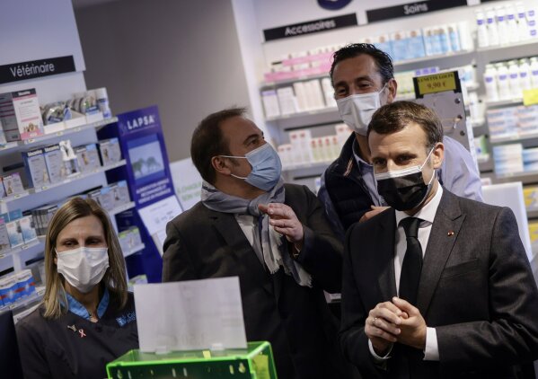 French President Emmanuel Macron visits a pharmacy in Valenciennes, northern France, Tuesday, March 23, 2021. The French government has backed off from ordering a tough lockdown for Paris and several other regions despite an increasingly alarming situation at hospitals with a rise in the number of COVID-19 patients. (Yoan Valat/Pool Photo via AP)