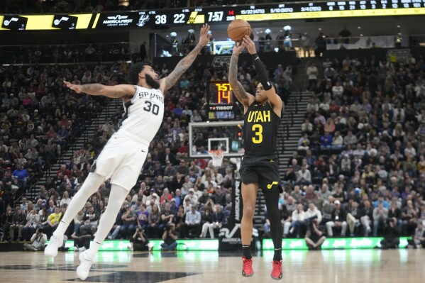 Utah Jazz guard Keyonte George (3) shoots as San Antonio Spurs forward Julian Champagnie (30) defends during the first half of an NBA basketball game Wednesday, March 27, 2024, in Salt Lake City. (AP Photo/Rick Bowmer)