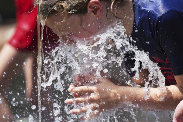 Jude Puroway cools off at a fountain during hot weather in Chicago, Sunday, June 22, 2025. (AP Photo/Nam Y. Huh)