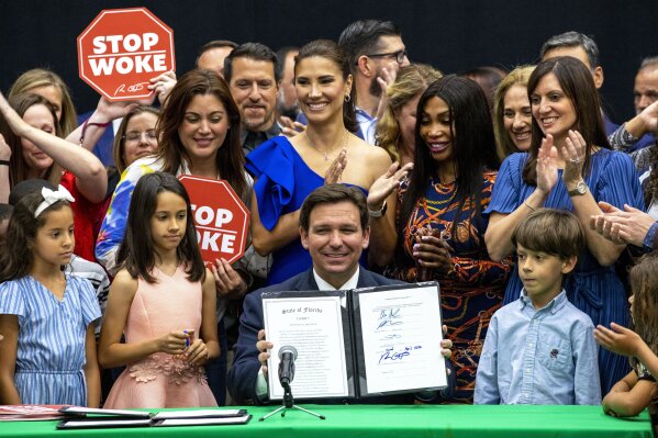 FILE - Florida Gov. Ron DeSantis smiles after publicly signing HB7, "individual freedom," also dubbed the "stop woke" bill during a news conference at Mater Academy Charter Middle/High School in Hialeah Gardens, Fla., on April 22, 2022. A federal appeals court has ruled that a Florida law pushed by Republican Gov. Ron DeSantis that limits diversity and race-based discussions in private workplaces is unconstitutional. A three-judge panel of the 11th U.S. Circuit Court of Appeals on Monday upheld a Florida federal judge’s August 2022 ruling that the so-called “Stop WOKE” act violates the First Amendment as it applies to businesses. The governor’s office Tuesday, March 5, 2024 was considering options for a further appeal. (Daniel A. Varela/Miami Herald via AP, file)