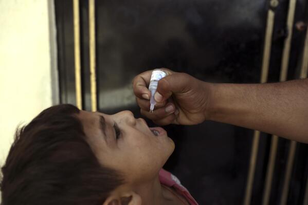 A health worker administers a vaccination to a child during a polio campaign in the old part of Kabul, Afghanistan, Tuesday, June 15, 2021. Gunmen on Tuesday targeted members of polio teams in eastern Afghanistan, killing some staffers, officials said. (AP Photo/Rahmat Gul)