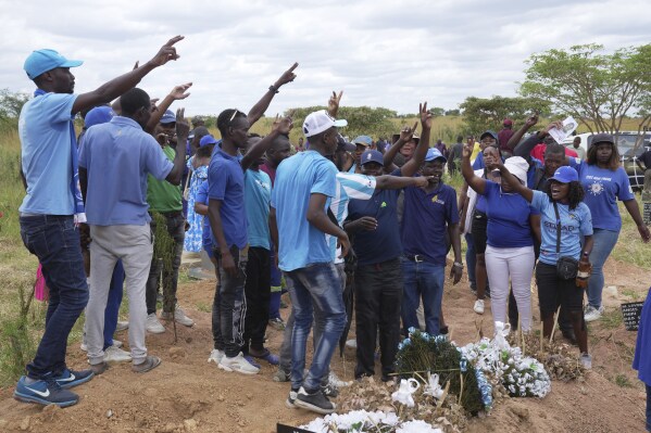 Opposition supporters chant party slogans at the burial of Moreblessing Ali, on the outskirts of Harare, Saturday, March, 2, 2024. A Zimbabwean activist slain two years ago was finally laid buried Saturday at a low key but tension filled event where tensions among party members betrayed the state of the country once promising opposition, which appears collapsing under the weight of infighting and allied state repression. (AP Photo/Tsvangirayi Mukwazhi)