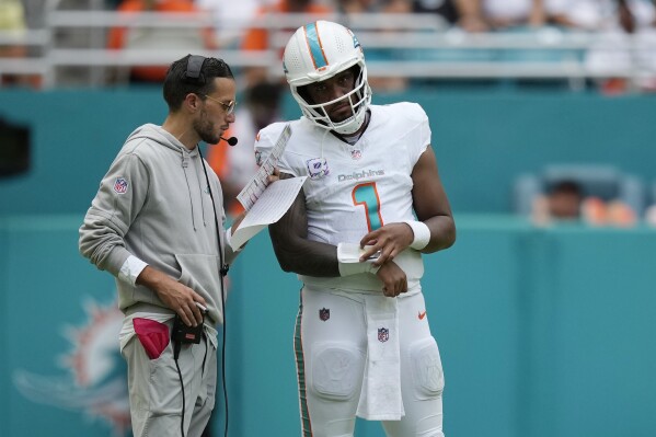 Miami Dolphins quarterback Tua Tagovailoa (1) listens to head coach Mike McDaniel during the second half of an NFL football game against the New York Giants, Sunday, Oct. 8, 2023, in Miami Gardens, Fla. (AP Photo/Rebecca Blackwell)