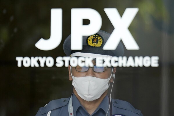 FILE - A security guard stands guard at an entrance of Tokyo Sock Exchange building on July 18, 2023, in Tokyo. Asian shares advanced Friday, Sept. 15, with solid gains for Chinese markets after the central bank eased the reserve requirements for banks to encourage more lending and prop up the slowing economy. (AP Photo/Eugene Hoshiko, File)