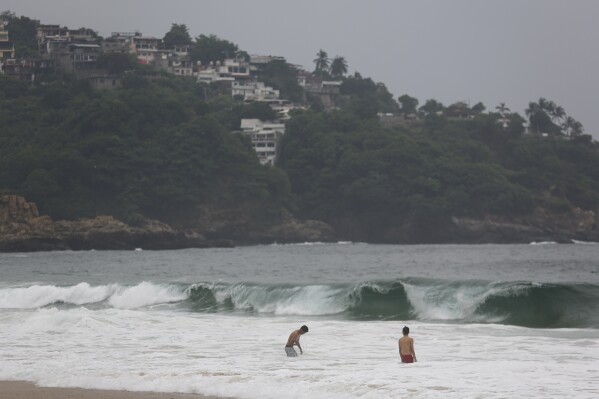 Tourists swim in Acapulco, Mexico, Tuesday, Oct. 24, 2023. Hurricane Otis has strengthened from tropical storm to a major hurricane in a matter of hours as it approaches Mexico's southern Pacific coast where it was forecast to make landfall near the resort of Acapulco early Wednesday. (AP Photo/Bernardino Hernandez)