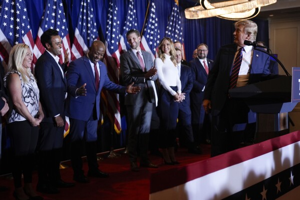 Republican presidential candidate former President Donald Trump turns to look at Sen. Tim Scott, R-S.C., as speaks at a primary election night party in Nashua, N.H., Tuesday, Jan. 23, 2024. (AP Photo/Matt Rourke)