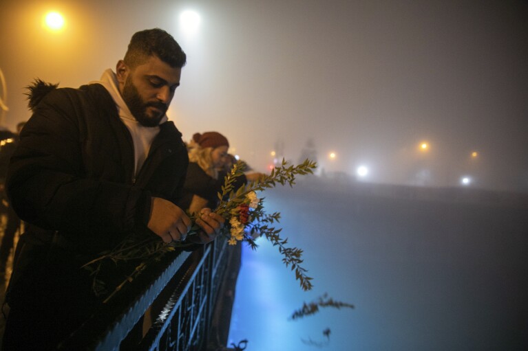 Orang-orang melemparkan bunga anyelir ke Sungai Orontes dalam rangka peringatan satu tahun bencana gempa bumi yang melanda negara itu, di kota Antakya, Turki selatan, Selasa, 6 Februari 2024. (AP Photo/Metin Yoksu)