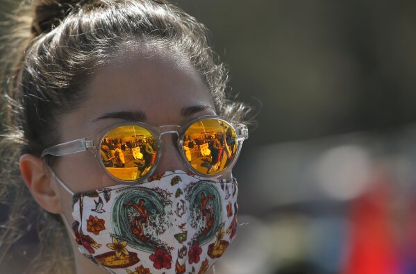 A woman attends a protest in front of the Serbian Parliament building in Belgrade, Serbia, Saturday, April 10, 2021. Environmental activists are protesting against worsening environmental situation in Serbia. (AP Photo/Darko Vojinovic)