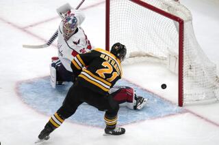 Boston Bruins right wing Garnet Hathaway (21) scores on Washington Capitals goaltender Darcy Kuemper (35) during the third period of an NHL hockey game Tuesday, April 11, 2023, in Boston. (AP Photo/Charles Krupa)