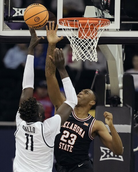 Oklahoma State center Brandon Garrison (23) blocks a shot by UCF forward Ibrahima Diallo (11) during the first half of an NCAA college basketball game Tuesday, March 12, 2024, in Kansas City, Mo. (AP Photo/Charlie Riedel)