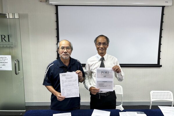 Robert Chung, right, president of the Hong Kong Public Opinion Research Institute, and current affairs commentator Johnny Lau, left, pose for photos ahead of a press conference in Hong Kong, Thursday, July 27, 2023. One of Hong Kong’s most reputable sources of public opinion data will stop releasing its poll results on a series of sensitive questions to the public, including on China’s Tiananmen Square crackdown in 1989 and Taiwan independence, in another example of the city's shrinking freedoms. (AP Photo/Kanis Leung)