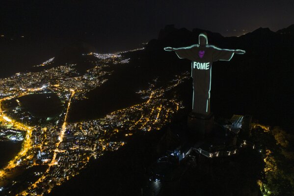 The Portuguese word "Hunger" is projected over the Rio's Christ the Redeemer statue amid the new coronavirus outbreak in Rio de Janeiro, Brazil, Sunday, May 10, 2020. (AP Photo/Leo Correa)
