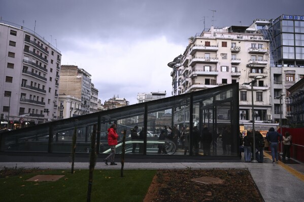 Commuters walk around a metro station during the inauguration day of the Thessaloniki metro, in Thessaloniki, northern Greece, Saturday, Nov. 30, 2024. (AP Photo/Giannis Papanikos)