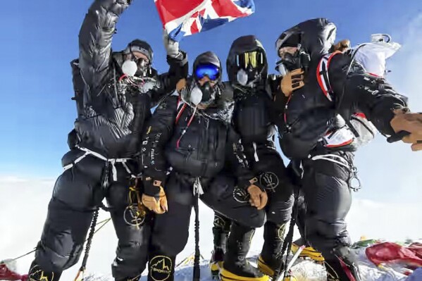 Four British climbers pose on the summit of Mount Everest less than a week after leaving London, in one of the fastest ascents on record of the world's highest peak, in Nepal, Wednesday, May 21, 2025. (Sandro Gromen via AP)
