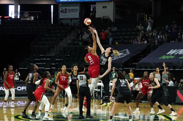 Las Vegas Aces' Liz Cambage (8) tips-off against Seattle Storm's Breanna Stewart to start the first half of a WNBA basketball game and their season Saturday, May 15, 2021, in Everett, Wash. (AP Photo/Elaine Thompson)