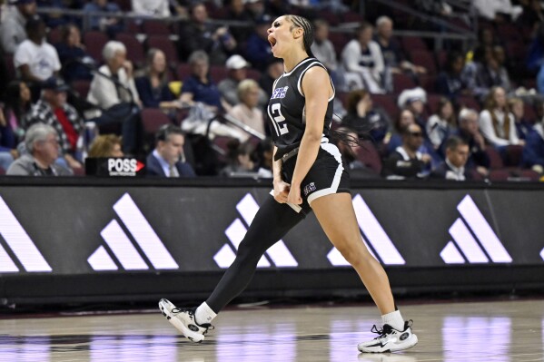 Stephen F. Austin guard Kyla Deck (12) reacts after a 3-point basket against California Baptist during the first half of an NCAA college basketball game in the championship of the Western Athletic Conference women's tournament, Saturday, March 16, 2024, in Las Vegas. (AP Photo/David Becker)