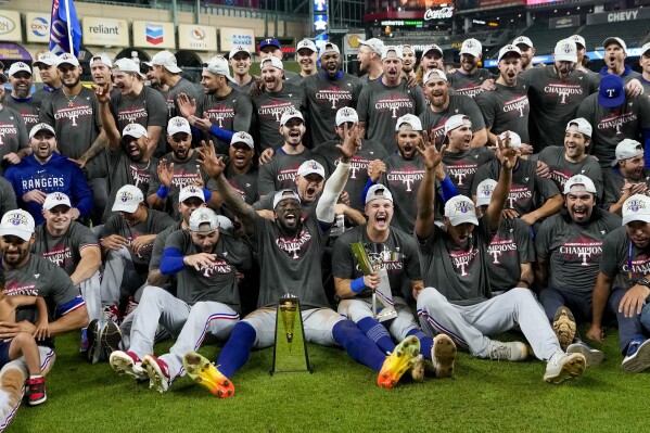 The Texas Rangers pose for a team picture after Game 7 of the baseball AL Championship Series against the Houston Astros Monday, Oct. 23, 2023, in Houston. The Rangers won 11-4 to win the series 4-3. (AP Photo/David J. Phillip)