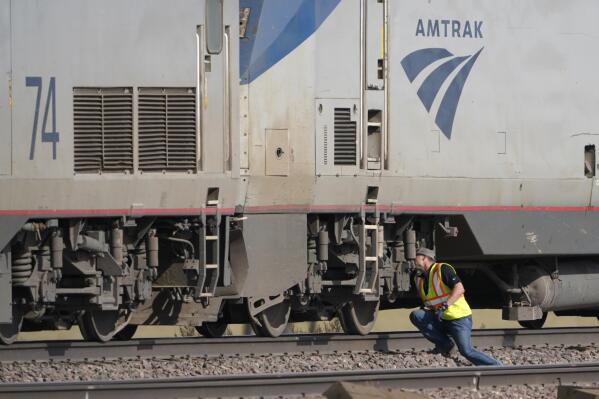 A worker peers under an Amtrak train engine, Sunday, Sept. 26, 2021, that was part of a train that derailed Saturday just west of Joplin, Mont. The westbound Empire Builder was en route to Seattle from Chicago, with two locomotives and 10 cars. (AP Photo/Ted S. Warren)