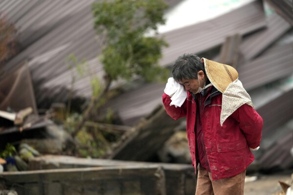 A man cries as a body of his family member was found from a collapsed house caused by powerful earthquake in Suzu, Ishikawa Prefecture Wednesday, Jan. 3, 2024. A series of powerful earthquakes hit western Japan, damaging buildings, vehicles and boats, with officials warning people in some areas on Tuesday to stay away from their homes because of a risk of more strong quakes. (AP Photo/Hiro Komae)