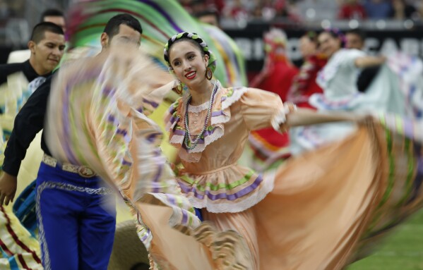 FILE - Performers participate in halftime actives in honor of Hispanic Heritage Month during an NFL football game between the San Francisco 49ers and the Arizona Cardinals, Sept. 21, 2014, in Glendale, Ariz. Hispanic history and culture take center stage across the U.S. for National Hispanic Heritage Month. The celebration recognizes contributions made by Hispanic Americans, the fastest-growing racial or ethnic minority according to the Census, and with a U.S. population of over 63 million people, there will be a plethora of Hispanic Heritage Month celebrations all over the country starting Friday, Sept. 15, 2023. (AP Photo/Ross D. Franklin, File)