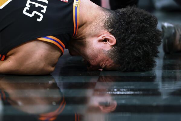 New York Knicks guard Quentin Grimes grimaces after suffering an injury during the first half of the team's NBA basketball game against the Miami Heat on Friday, Feb. 25, 2022, in New York. (AP Photo/Jessie Alcheh)
