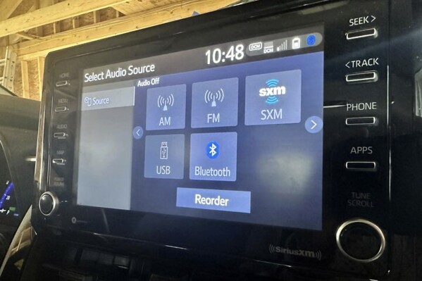 A display screen inside a vehicle shows various radio options, including AM radion, Monday, March 11, 2024, in Bow, N.H. Politicians are closing in on the required number of votes needed to pass federal legislation that requires AM radios in every new car. The prevalence of AM broadcast radio has dipped in recent decades as more listeners turn to options such as satellite radio and podcasts while driving, but a large, bipartisan group of lawmakers believes saving the AM dial is critical to public safety, especially in rural America, and they want to ensure access to it via car radios. (AP Photo/Holly Ramer)