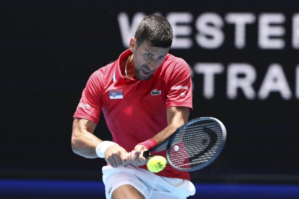 Novak Djokovic of Serbia hits a return to Jiri Lehecka of the Czech Republic during the United Cup tennis tournament in Perth, Australia, Tuesday, Jan. 2, 2024.(AP Photo/Trevor Collens)