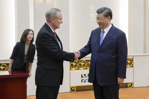 Thượng nghị sĩ Hoa Kỳ Mike Crapo, R-Idaho, trái, được Chủ tịch Trung Quốc Tập Cận Bình chào đón trước cuộc gặp song phương của họ tại Đại lễ đường Nhân dân ở Bắc Kinh, Thứ Hai, ngày 9 tháng 10 năm 2023. (Ảnh AP / Andy Wong, Pool)